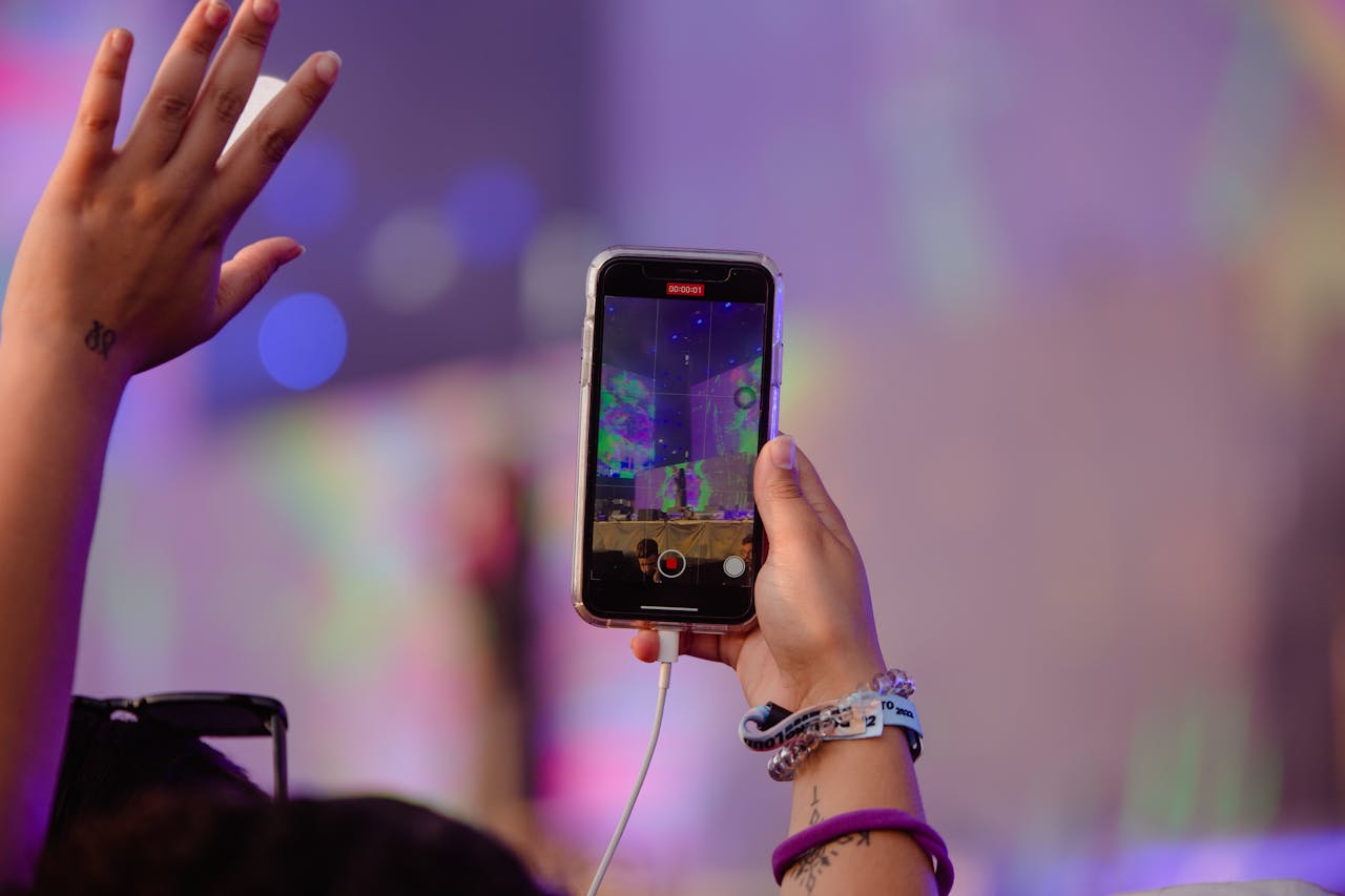 A person records a live event using their smartphone, creating vibrant memories.